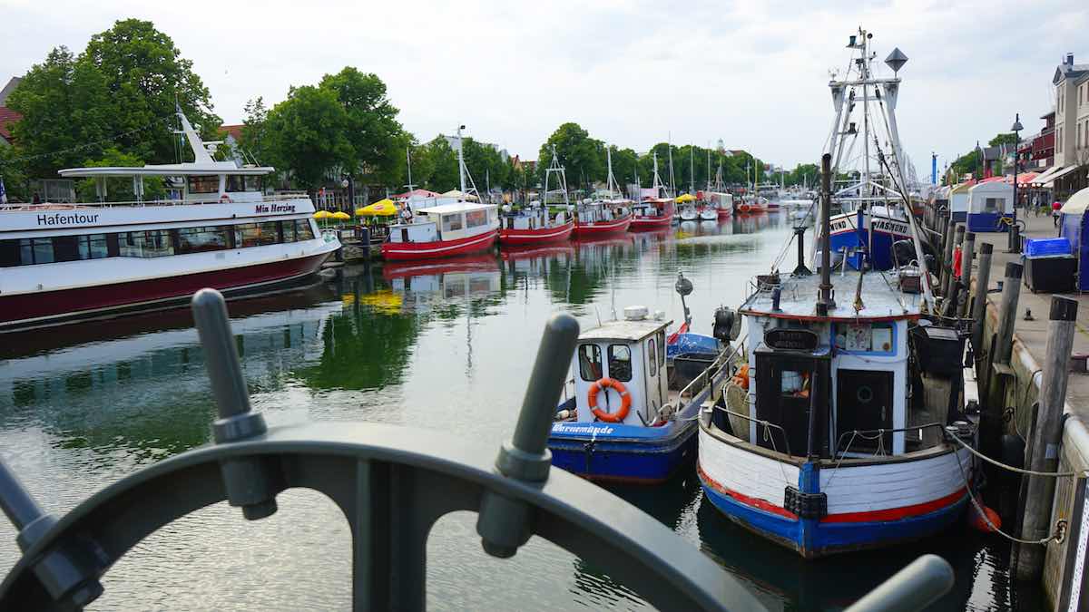 Blick in der Fischereihafen von Warnemünde. Im Vordergrund ein Teil der Drehmechanik der Bahnhofsbrücke – Foto: Beate Ziehres